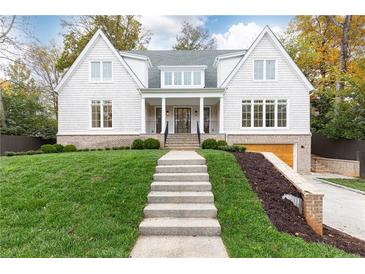 Two-story home with white siding, brick accents, and a landscaped lawn at 2624 Forrest Ne Way, Atlanta, GA 30305