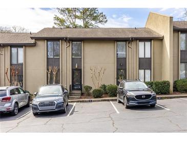 Tan colored exterior of townhouse with parking in front at 15 Ivy Ne Sq, Atlanta, GA 30342