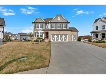 Two-story house with gray siding, three-car garage, and landscaped yard at 12 Ridgeline Nw Way, Cartersville, GA 30121