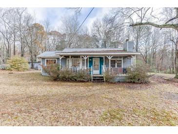 Cozy gray house with teal door and porch, nestled on a grassy lot at 4571 Bennett Rd, Buford, GA 30519