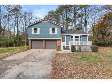 Charming blue two-story home with a two-car garage and front porch at 5160 Sheppard Ct, Stone Mountain, GA 30083