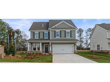 Two story house with gray siding, white garage door, and landscaping at 412 Brekston Way, Mcdonough, GA 30253