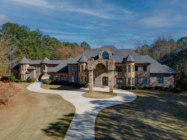 Grand stone chateau style home with a large circular driveway at 595 S Mount Carmel Rd, Mcdonough, GA 30253