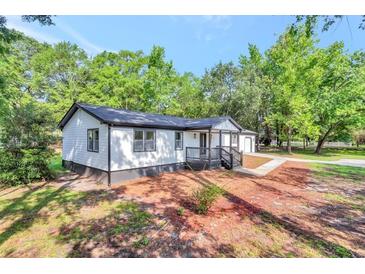 Newly renovated house with a white exterior, gray accents, and a spacious front yard at 2139 Rosebud Rd, Grayson, GA 30017