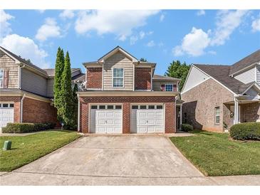 Brick townhouse with a two-car garage and well-manicured lawn at 24 Chantilly Pl, Mcdonough, GA 30253