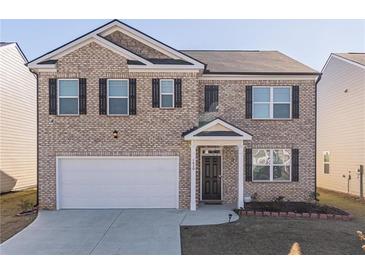 Two-story brick home with a large driveway and landscaping at 1829 Redfern Rd, Dacula, GA 30019