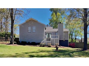 Gray house with deck, green lawn, and mature trees in the backyard at 2193 Hampton Se Trl, Conyers, GA 30013