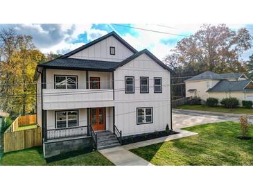 Two-story home with modern farmhouse design, featuring a bright orange door and landscaped lawn at 4562 Spring St, Acworth, GA 30101