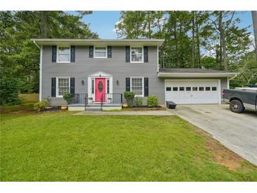 Two-story house with gray siding, pink door, and attached garage at 2722 Ashworth Cir, Snellville, GA 30078