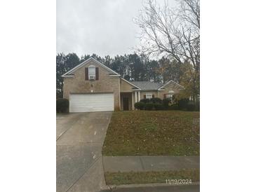 Brick house with attached garage and landscaped yard at 4254 Wood Cove Dr, Snellville, GA 30039