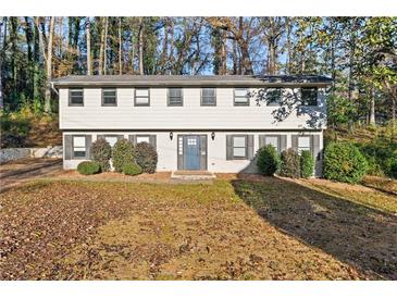 Two-story house with gray door and white siding, surrounded by trees and leaves at 3073 Capri Ct, East Point, GA 30344