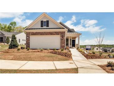 Brick and shingle ranch home with a two-car garage and landscaped yard at 5763 Grapewood St, Hoschton, GA 30548