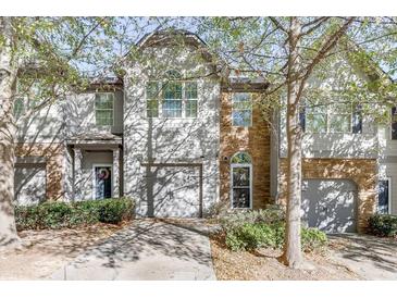 Two-story townhome with gray siding, stone accents, and a two-car garage at 510 Jefferson Chase St, Atlanta, GA 30354