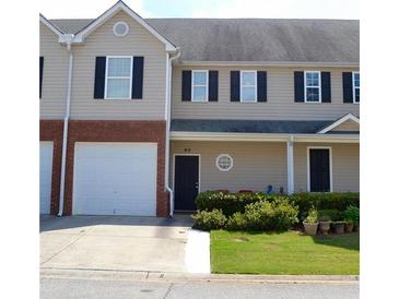 Two-story townhome with a tan exterior, black shutters, and a two-car garage at 45 Eagle Glen Ne Dr, Cartersville, GA 30121