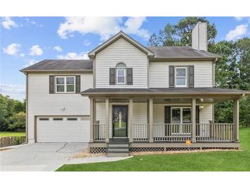 Two-story house with a large front porch and attached garage at 2852 Emerson Lake Dr, Snellville, GA 30078