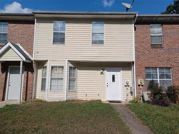 Brick and vinyl siding townhouse with a white door and small front yard at 8538 Westchester Dr, Douglasville, GA 30134