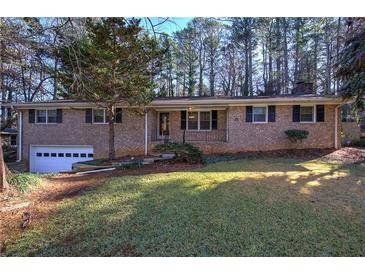 Brick ranch house with attached garage and landscaped lawn at 3854 Westmoreland Nw Dr, Kennesaw, GA 30144