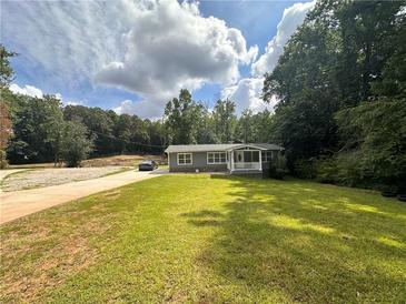 Ranch home with gray siding, white trim, and a covered porch sits on a grassy lot at 1581 Cheryl Leigh Dr, Riverdale, GA 30296