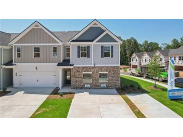 Two-story townhome with gray and beige siding, brick accents, and a two-car garage at 318 Crimson Dr, Union City, GA 30291