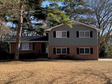 Two-story brick and gray house with a large yard at 5470 Chanterella Sw Ct, Lilburn, GA 30047