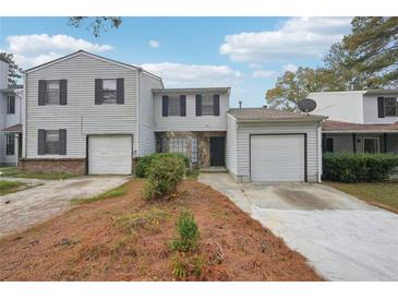 Two-story townhome with attached garage and landscaping at 703 Pine Tree Trl, Atlanta, GA 30349