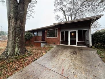 Brick ranch house with screened porch and driveway at 2069 Bixler Cir, Decatur, GA 30032