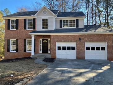 Brick two-story house with a two-car garage and landscaping at 1870 Fairpointe Trce, Stone Mountain, GA 30088