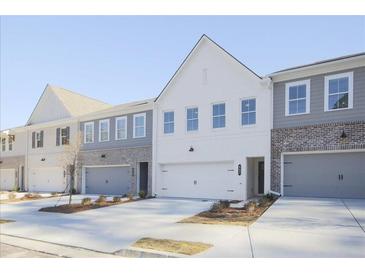 Modern townhome community with gray and white exteriors, two-car garages, and landscaping at 907 Agate Ln, Lawrenceville, GA 30043