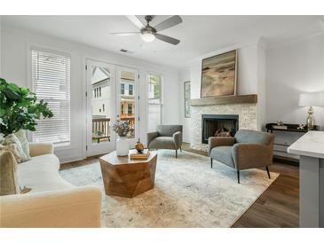 Bright living room with fireplace, wood floors, and access to a balcony at 2541 High Brow St # 40, Duluth, GA 30096