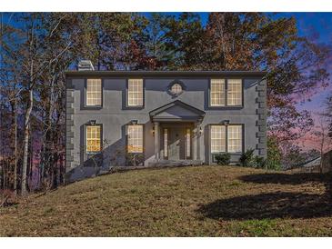 Two-story house with gray stucco siding, multiple windows, and a manicured lawn at 508 Sutters Mill Rd, Stone Mountain, GA 30087