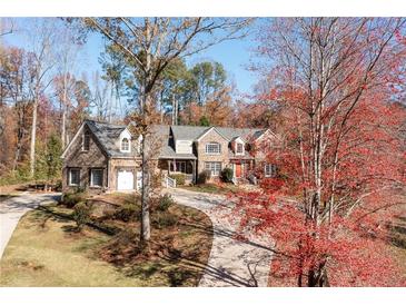 Stone house with a large driveway and landscaping at 355 Clark Creek Pass, Acworth, GA 30102