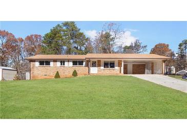 Ranch house with brick facade, carport, and spacious lawn at 5916 N Bear Dr, Douglasville, GA 30135