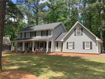 Two-story house with gray siding, a covered porch, and a well-maintained lawn at 714 Lanford Springs Sw Dr, Lilburn, GA 30047