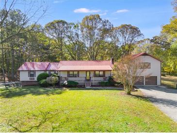 Ranch style home with red metal roof, large yard, and attached garage at 495 Gray Rd, Carrollton, GA 30116