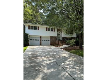 Ranch style home with two-car garage and mature landscaping at 4681 Mercer Rd, Stone Mountain, GA 30083