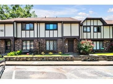 Inviting townhome exterior with landscaping and stone accents at 1192 Ashborough Se Dr # E, Marietta, GA 30067