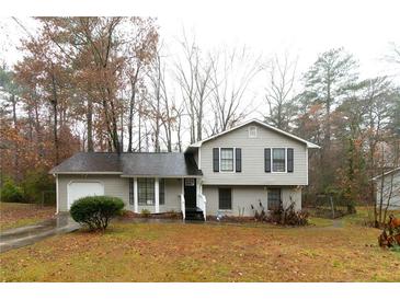 Gray two-story house with attached garage and landscaping at 1841 Northwick Pl, Lithonia, GA 30058