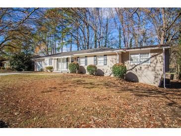 Ranch style home with a spacious lawn and mature trees at 2496 Montezuma Cir, Ellenwood, GA 30294