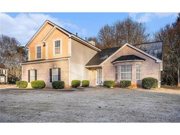 Two-story brick home with a landscaped lawn and mature trees at 4088 Smithfield Trl, Ellenwood, GA 30294