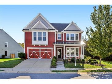 Charming two-story red home with a welcoming front porch and attached garage at 100 Academy Ln, Canton, GA 30114