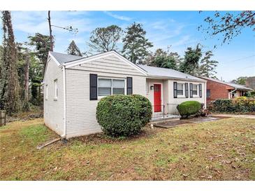 Brick ranch home with red door, landscaping, and a spacious yard at 2671 Tilson Rd, Decatur, GA 30032