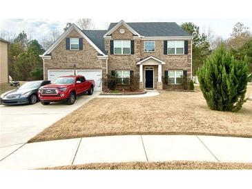 Two-story brick home with a spacious lawn and driveway at 1291 Vienna Ct, Hampton, GA 30228