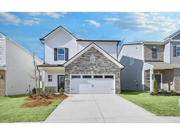 Charming two-story home with stone and siding exterior, front yard landscaping, and attached two-car garage at 2700 Ravencliff Dr, Austell, GA 30168