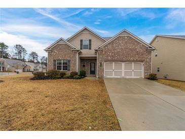 Charming two-story home with brick and siding exterior, three-car garage, and landscaped front yard at 2430 Melton Common Dr, Dacula, GA 30019