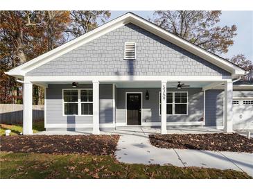 Gray house with white columns, front porch, and a two-car garage at 5359 Megan Rd, Stone Mountain, GA 30088