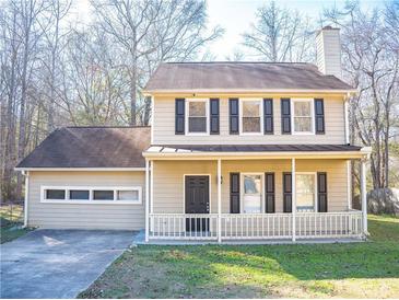 Two-story house featuring a beige exterior, brown roof, and a front porch at 608 Woodknoll Ct, Jonesboro, GA 30238