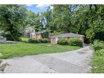 Brick ranch home with a driveway and a grassy yard at 1279 Kenilworth Sw Dr, Atlanta, GA 30310