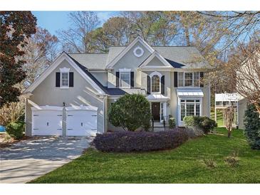 Charming two-story home with a two-car garage, landscaped yard, and mature trees at 185 Witheridge Dr, Johns Creek, GA 30097