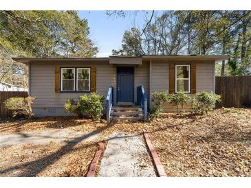 Newly renovated ranch home with blue door and landscaped yard at 501 Aberdeen Nw Dr, Atlanta, GA 30318