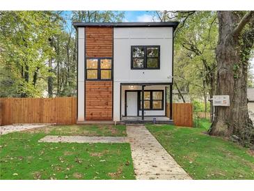 Modern two-story house with wood and white exterior, landscaped lawn, and fenced yard at 1930 Pinedale Nw Dr, Atlanta, GA 30314